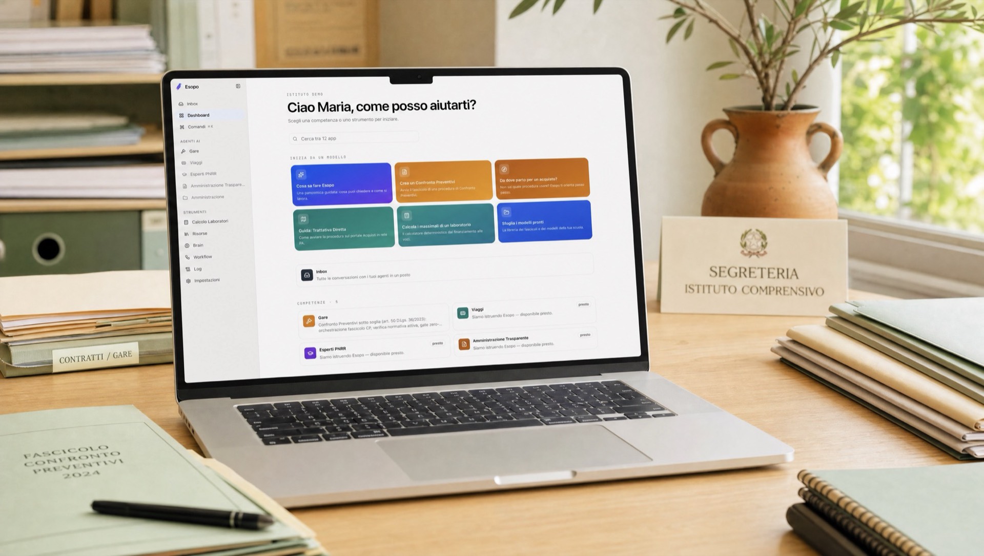 Un MacBook su una scrivania di segreteria scolastica con la dashboard di Esopo sullo schermo, luce naturale, raccoglitori e ramo d'ulivo sullo sfondo